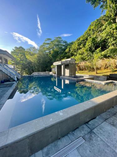 a pool of blue water with trees in the background at Ngermid Oasis - Charming 1 BD/1.5 BA Duplex in Koror