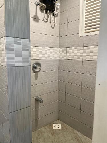 a shower with gray tiles and a shower at Ngermid Oasis - Charming 1 BD/1.5 BA Duplex in Koror