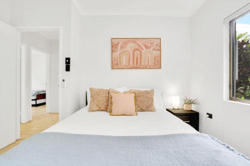 Habitación blanca con cama grande con almohadas en Comino on Connemara en Trinity Beach