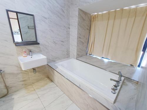 a white bathroom with a tub and a sink at Imperio Residence Melaka by Jeffery Lam Home Management in Melaka