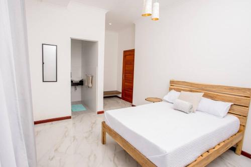 Schlafzimmer mit einem Bett mit weißer Bettwäsche in der Unterkunft T&T Apartment in Ndola