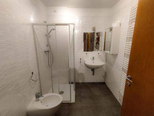 La salle de bains est pourvue d'une douche, d'un lavabo et de toilettes. dans l'établissement Residence Europa, à Sistiana
