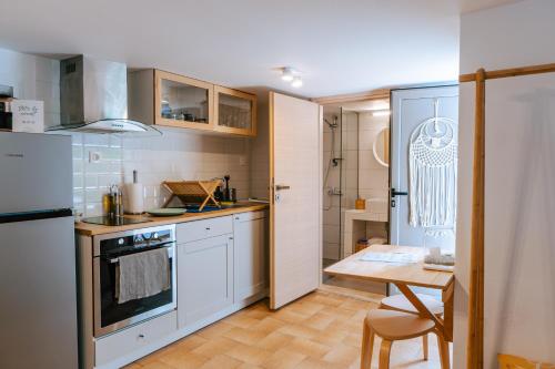 una cocina con armarios blancos y una mesa. en Sibylla Studio Deluxe, en Kalymnos