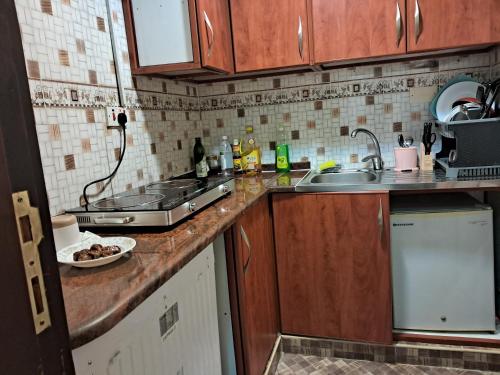 a kitchen with a sink and a counter top at Apex Inn - 7 Min To Zayed Airport in Al Qurayyah