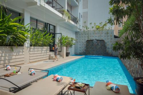a man standing next to a swimming pool in a building at Angkor Aurora in Siem Reap