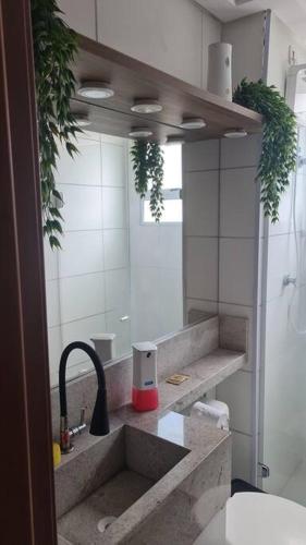 a bathroom with a sink and a mirror at Apartament litoral norte NatalRN in Natal