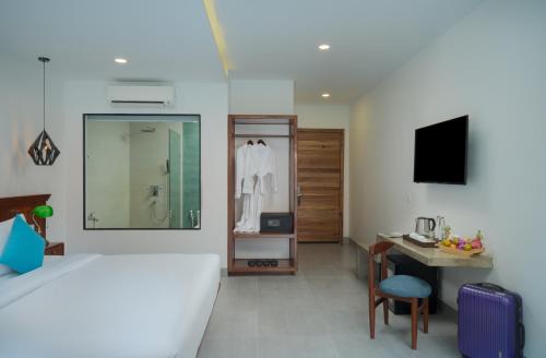 a bedroom with a bed and a desk and a television at Angkor Aurora in Siem Reap
