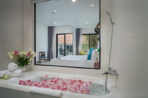 baño con bañera llena de flores rosas en Angkor Aurora, en Siem Reap