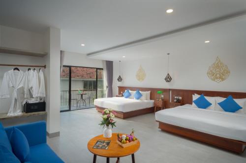a hotel room with two beds and a table at Angkor Aurora in Siem Reap