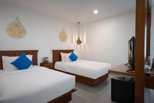 a hotel room with two beds and a television at Angkor Aurora in Siem Reap