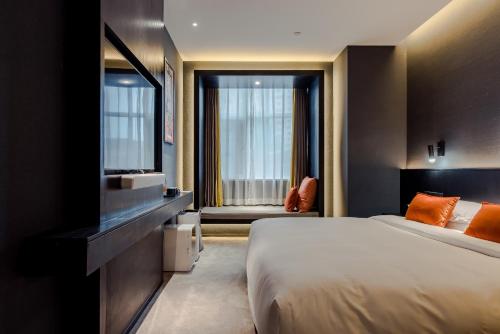 西安市にあるSOON DESIGNER HOTEL Xi'an Drum Tower & YONGNING Gate Branchのベッド1台、薄型テレビが備わるホテルルームです。