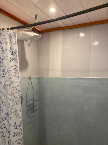um quarto com uma cortina de chuveiro num quarto em Mario´s Lodge Providencia em El Copey