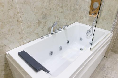 a white bath tub in a bathroom at D' Elmer's Resort and Convention Hotel in Dinadiwan