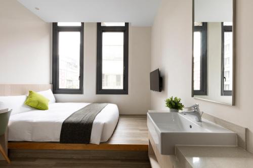a bedroom with a bed and a sink and a tub at Meander 1948 in Taipei