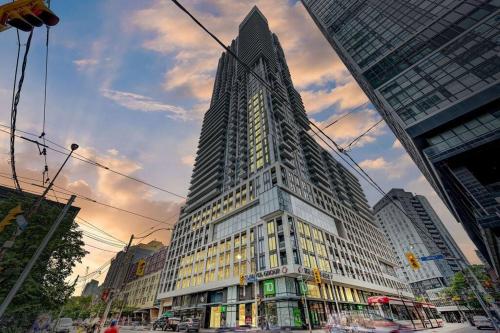 a tall building in the middle of a city at Cozy Condo Near EatonCentre Mall in Toronto