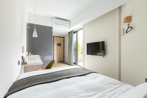 a bedroom with a bed and a tv on a wall at Meander 1948 in Taipei