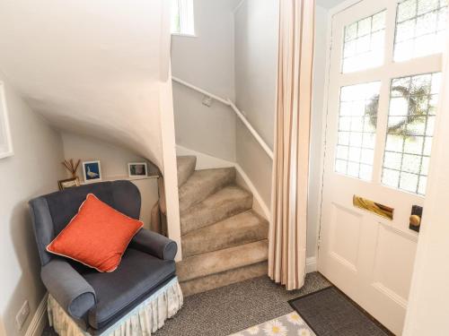 a stairwell with a chair and stairs with a window at Bishop Howe in Far Sawrey