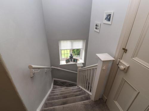 a stairway with a stair railing and a window at Bishop Howe in Far Sawrey