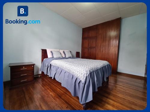 a bedroom with a bed and a wooden cabinet at Departamento en Centro Histórico in Cuenca