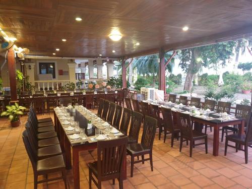 uma sala de jantar com mesas longas e cadeiras em Sài Gòn Côn Đảo Resort em Con Dao
