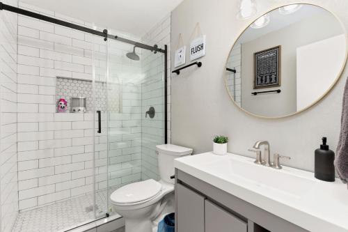 a bathroom with a toilet and a sink and a mirror at Home with pool and games in central San Antonio in San Antonio