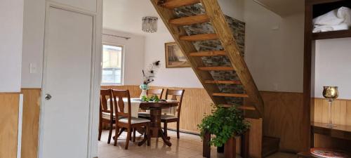 ein Esszimmer mit einem Tisch und einer Wendeltreppe in der Unterkunft Casa en Lautaro in Lautaro