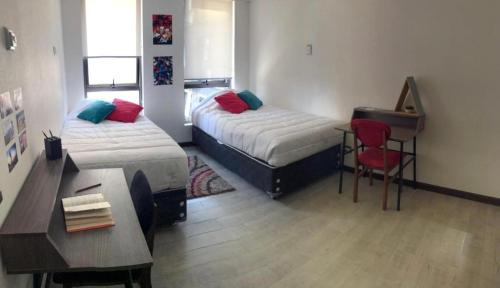 Habitación de hotel con 2 camas, escritorio y escritorio. en Departamento Arequipa, en Arequipa