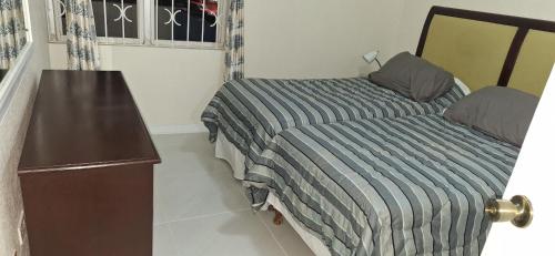 a bedroom with a bed and a dresser next to it at Seaview Property 1C Two Bedroom Apt Hasting Towers in Bridgetown