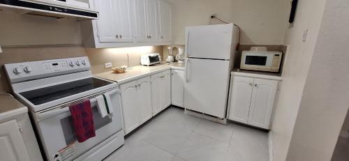 a kitchen with white appliances and white cabinets at Seaview Property 1C Two Bedroom Apt Hasting Towers in Bridgetown