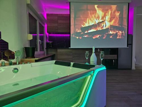 a bath tub in a room with a fireplace at L'Appart Spa, Jacuzzi & Sauna in Differdange