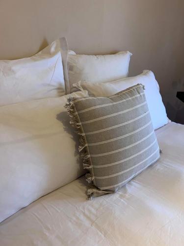 a pillow sitting on top of a bed with pillows at The Thirsty Farmer 