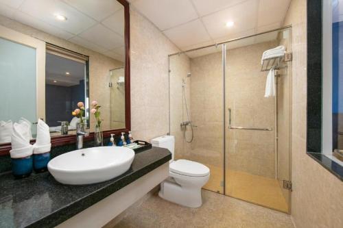 La salle de bains est pourvue d'un lavabo, de toilettes et d'une douche. dans l'établissement Coecco Xieng Khouang Hotel, à Ban Nafèng