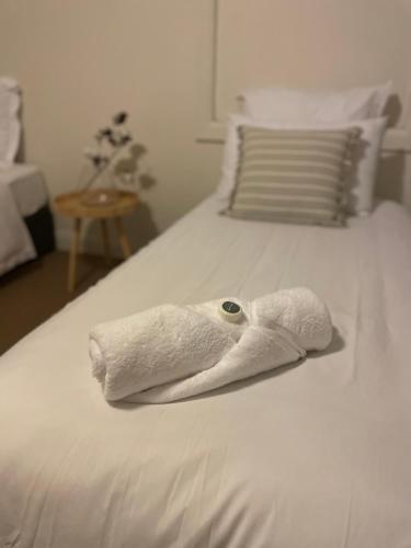 a white towel on a white bed at The Thirsty Farmer 