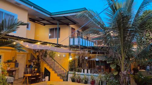 a building with a staircase and a palm tree at Abihon HoferHaus Mactan Guesthouse in Lapu Lapu City