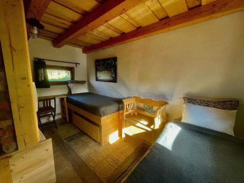 a room with two beds and a table and a chair at Nature Lodge Csesztve in Csesztve