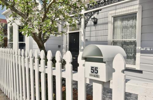 a white picket fence in front of a house at In Dunedin's Heart, Full House, Full Sun, Full Chill, Why Stay at a Hotel When You Can Afford an Entire House in Dunedin