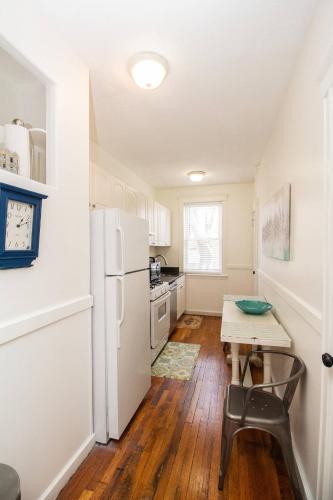 a kitchen with a table and a white refrigerator at 05mile to Boston Childrens, Brigham, Dana F, BI in Longwood Station
