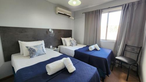 a hotel room with two beds and a window at Essencial Hotel & Spa in Mendoza