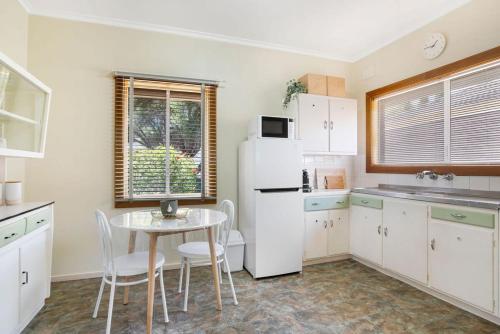 a kitchen with a table and a white refrigerator at The Peach Tree 2 Bed Home in Elizabeth