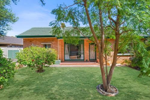 a house with a tree in the yard at The Peach Tree 2 Bed Home in Elizabeth