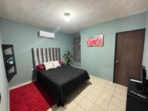 een slaapkamer met een bed en een rood tapijt bij Acogedor depa cerca del Tec in Ciudad Victoria