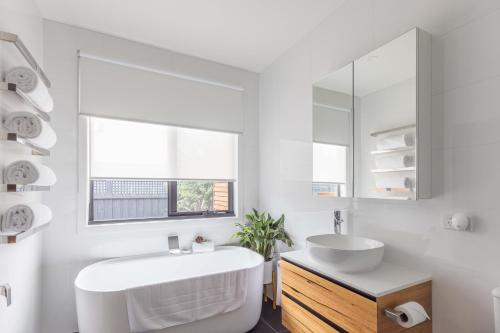 uma casa de banho branca com uma banheira e um lavatório em Lancefield Luxury Guest Suite - DoubleDare em Lance Field
