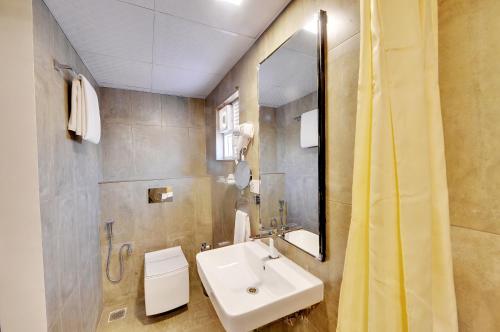 a bathroom with a sink and a mirror at The Lavender Hotel in Bangalore