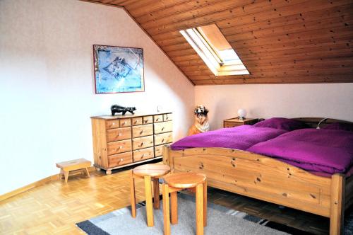 ein Schlafzimmer mit einem großen Holzbett mit violetter Bettwäsche in der Unterkunft Ferienwohnung Eudenbach in Alsbach