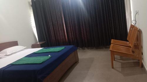a bedroom with a bed and a chair and a window at Green Valley Holiday Home in Meppādi