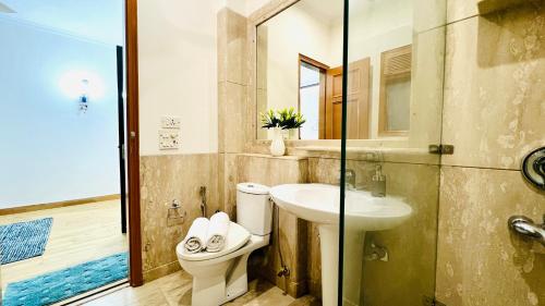 a bathroom with a toilet and a sink at BluO Vasant Vihar PVR - Kitchen, Terrace, Lift in New Delhi