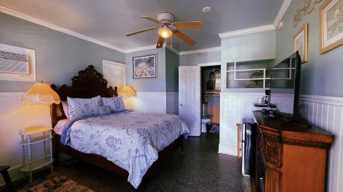 a bedroom with a bed and a ceiling fan at Shamrock Cove Inn in Ocala