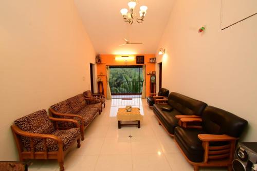 a living room with a couch and a table at Green Valley Holiday Home in Meppādi