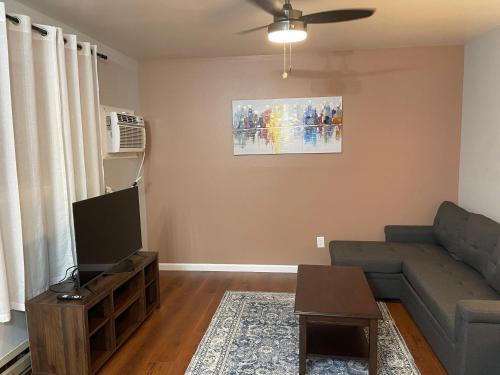 a living room with a couch and a tv at UMC Apartments in Oklahoma City