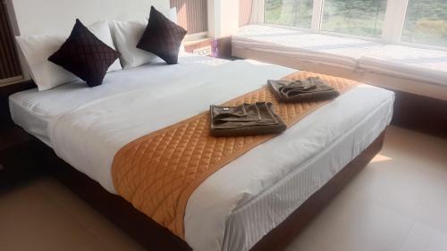 a bedroom with a bed with two towels on it at Green Valley Holiday Home in Meppādi